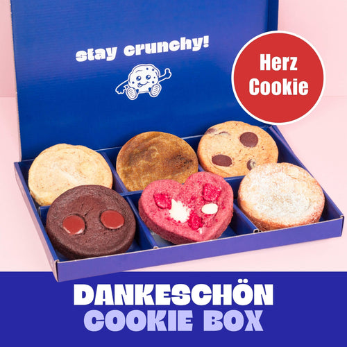 Deichkeks 6er BIG Cookie Box – handgemachte vegane Cookies: Macadamia White Choc, Franzbrötchen Style, Chocolate Chip, Double Choco, Himbeere White Choc und Mandelcroissant in blauer Geschenkbox.